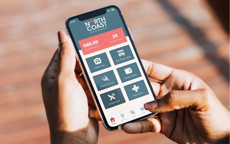 hands holding phone displaying car wash app