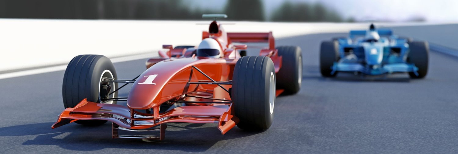 red race car ahead of a blue race car on a track