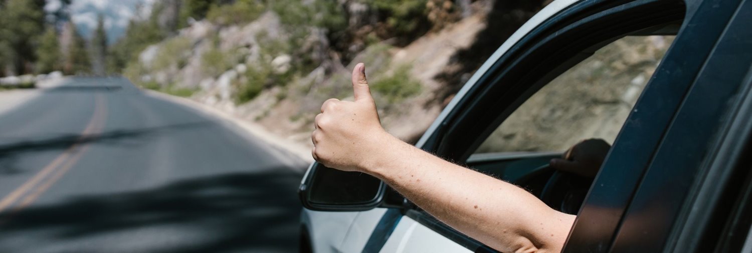 car driving down a blurred tree-lined street