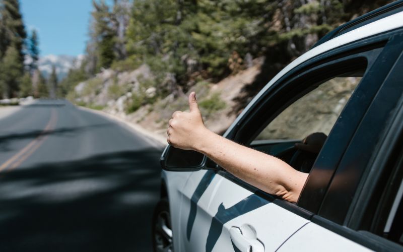 car driving down a blurred tree-lined street