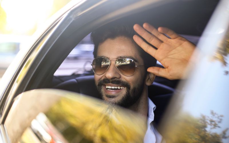 important looking man waving from a vehicle