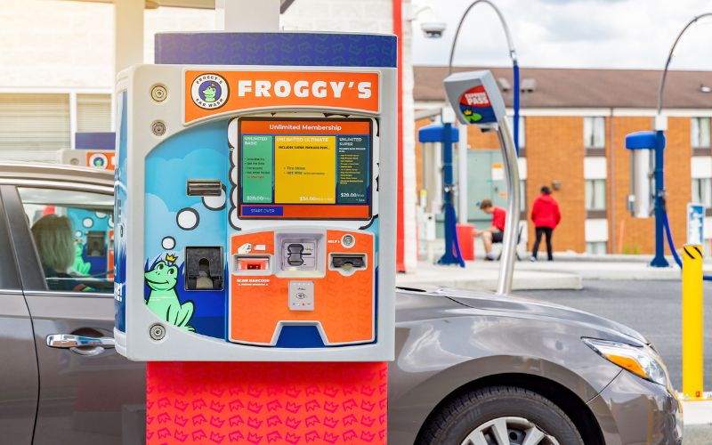 focus on a car wash pay station in a line with other lanes in the background