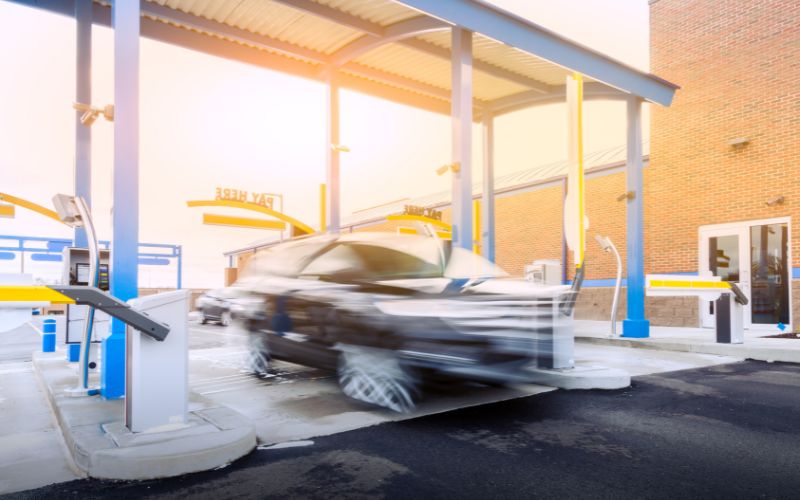 blurry car zooming through a car wash pay station lane