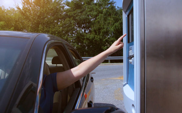 car wash customer reaching out to use a DRB pay station built by Unitec