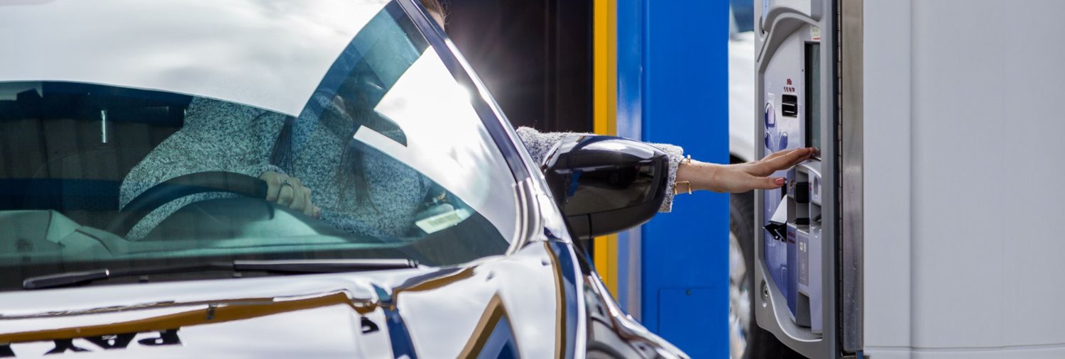 a driver pulls up beside a car wash pay station