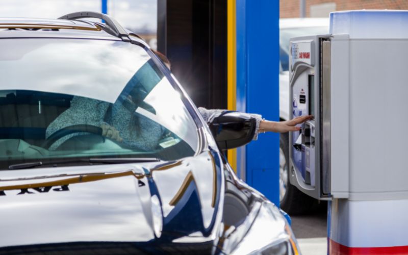 a driver pulls up beside a car wash pay station