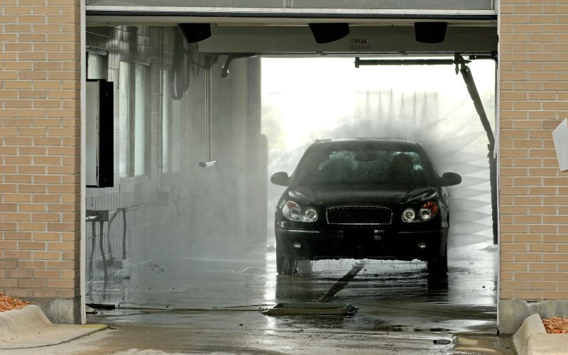black car inside an operating in-bay automatic car wash