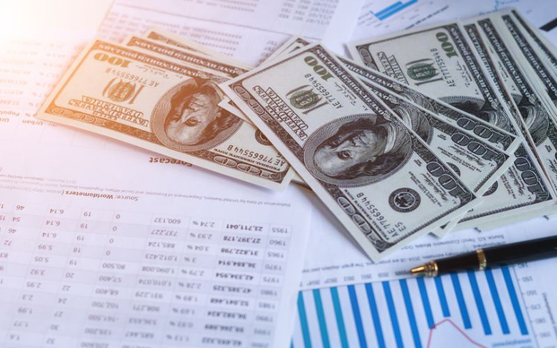 $100 bills spread out over reports