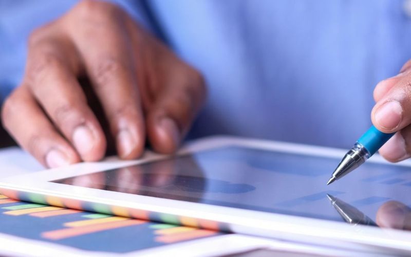 hand holding a pen pointing at a tablet