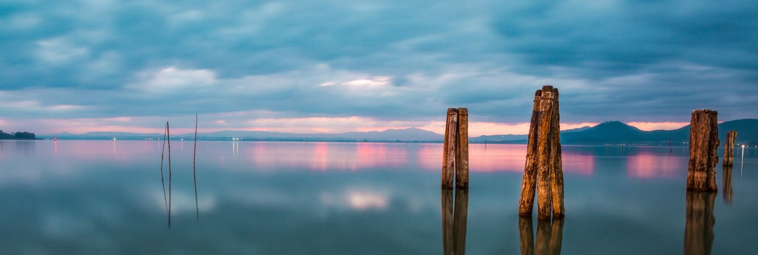 four wood pillars sticking out of a body of water