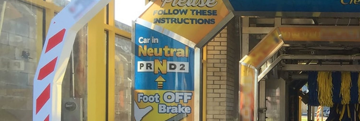 sign inside car wash tunnel instructing customers to keep car in neutral and foot off the brake