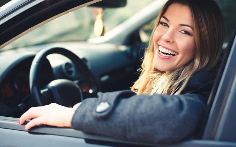 Smiling woman behind wheel of car