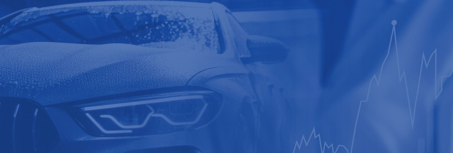 hands holding phone in front of a car steering wheel