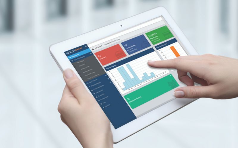 closeup of someone using a tablet displaying sitewatch web car wash reports