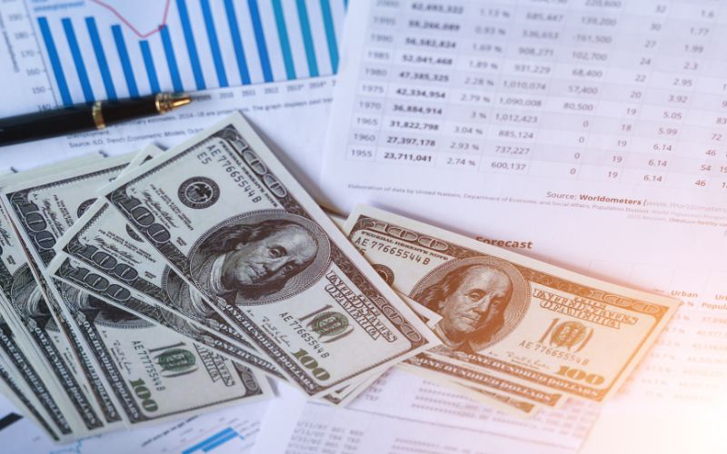 money and a pen sitting on printed reports