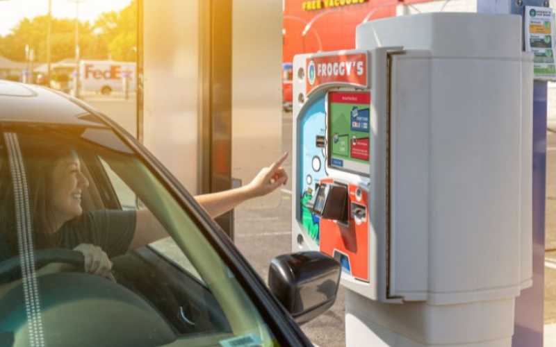 driver at car wash pay station smiling